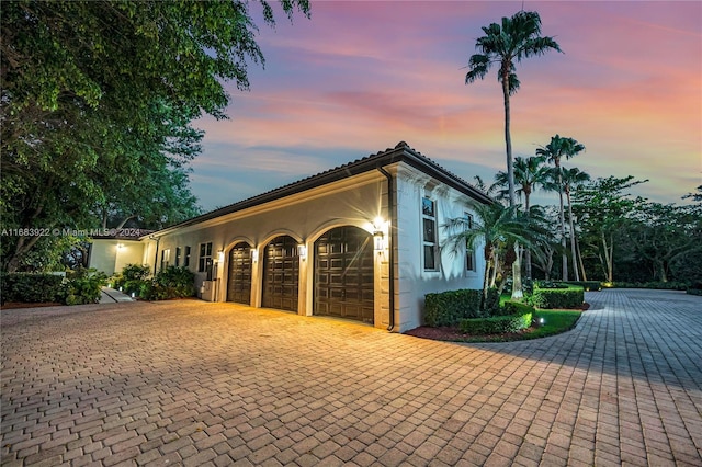 property exterior at dusk featuring a garage