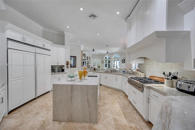 kitchen featuring decorative backsplash, kitchen peninsula, white cabinets, and light stone counters