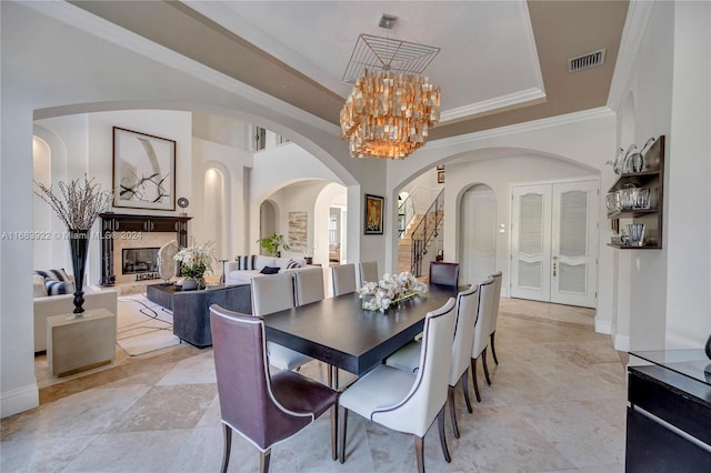 dining space with a premium fireplace and crown molding