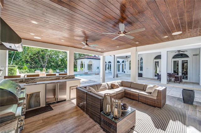 view of patio / terrace with an outdoor kitchen, french doors, sink, and ceiling fan