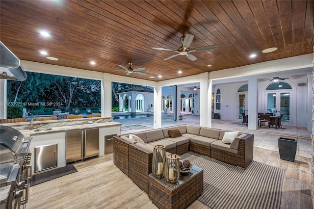 view of patio / terrace with an outdoor kitchen, an outdoor hangout area, ceiling fan, french doors, and sink