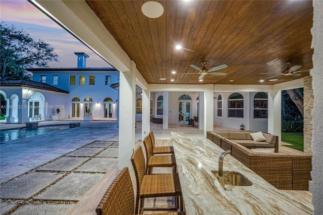 exterior space featuring a patio, ceiling fan, sink, and an outdoor hangout area