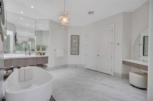 bathroom featuring a bathtub, a notable chandelier, and vanity