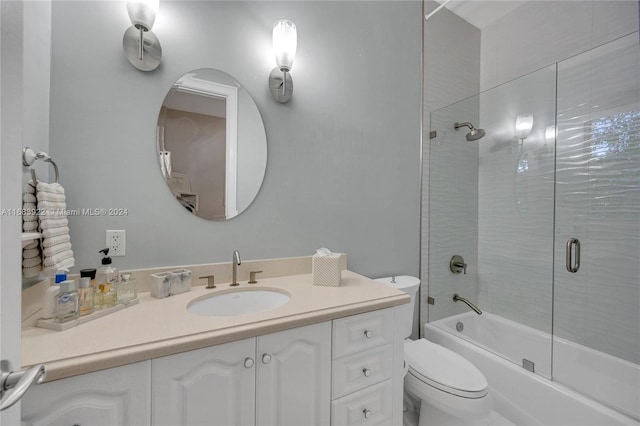 full bathroom featuring toilet, combined bath / shower with glass door, and vanity