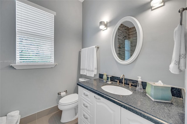 bathroom with toilet, vanity, and tile patterned floors