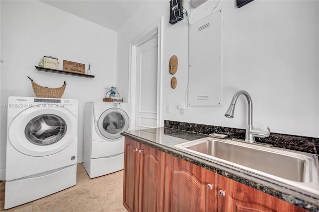 laundry area featuring sink, washing machine and clothes dryer, and cabinets