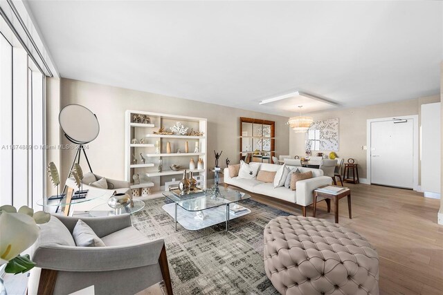 living room featuring a healthy amount of sunlight, a chandelier, and wood-type flooring