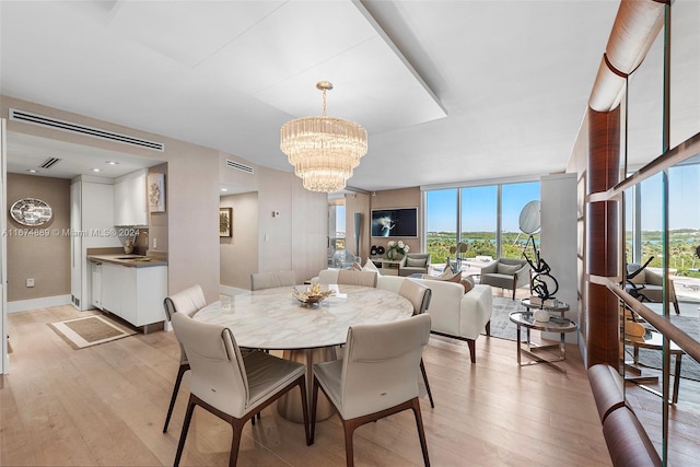 dining room featuring a chandelier, light hardwood / wood-style floors, and expansive windows