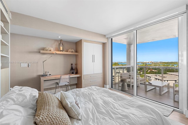 bedroom with access to outside and hardwood / wood-style flooring