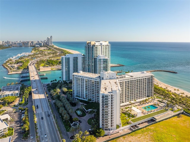 birds eye view of property featuring a water view and a beach view