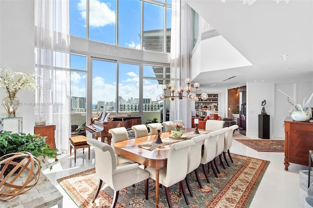 dining area featuring a towering ceiling and a notable chandelier