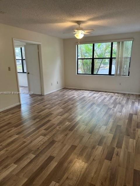 spare room featuring dark hardwood / wood-style floors, a textured ceiling, plenty of natural light, and ceiling fan