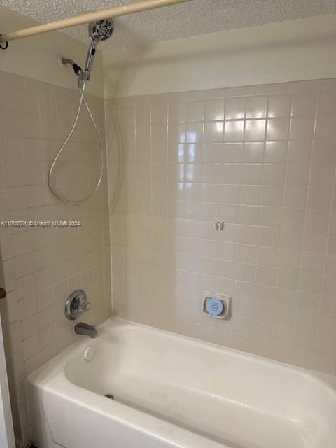 bathroom featuring tiled shower / bath combo and a textured ceiling