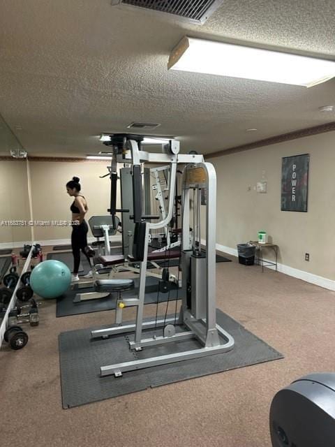 gym featuring crown molding and a textured ceiling