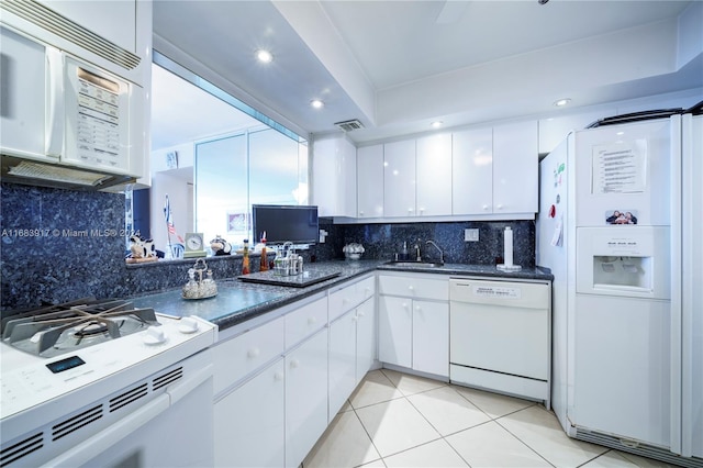 kitchen with white appliances, sink, backsplash, white cabinets, and light tile patterned floors