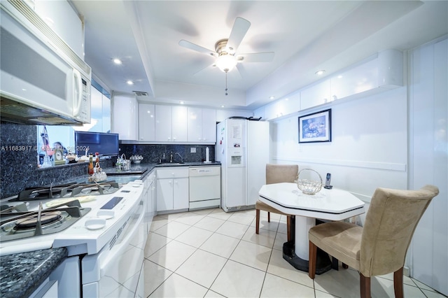 kitchen with tasteful backsplash, light tile patterned floors, ceiling fan, white cabinetry, and white appliances