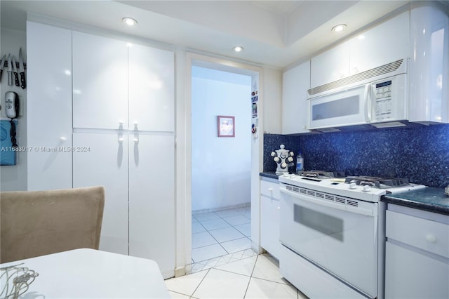 kitchen with backsplash, white cabinetry, white appliances, and light tile patterned floors