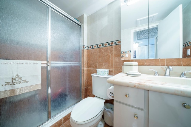 bathroom with toilet, vanity, tile walls, and a shower with door