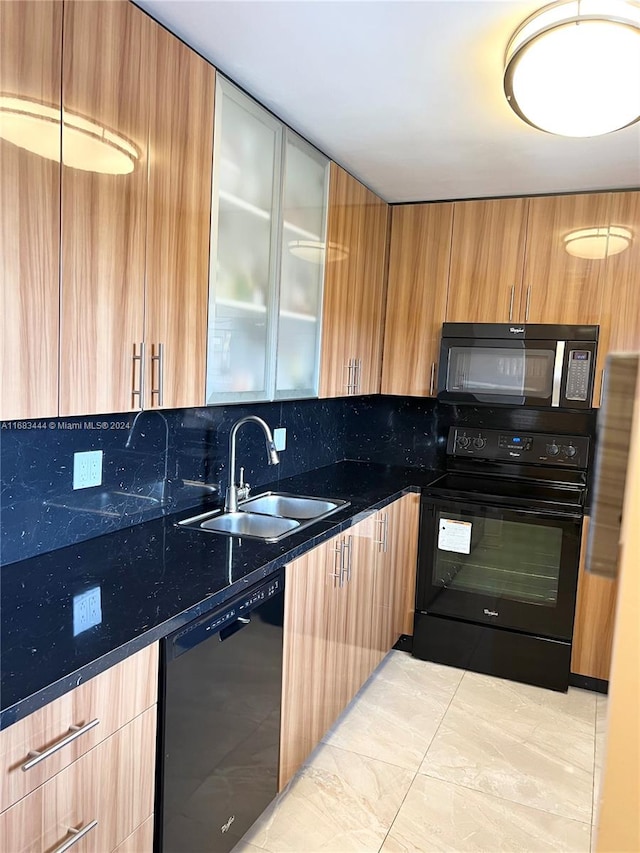 kitchen featuring tasteful backsplash, black appliances, sink, and dark stone counters