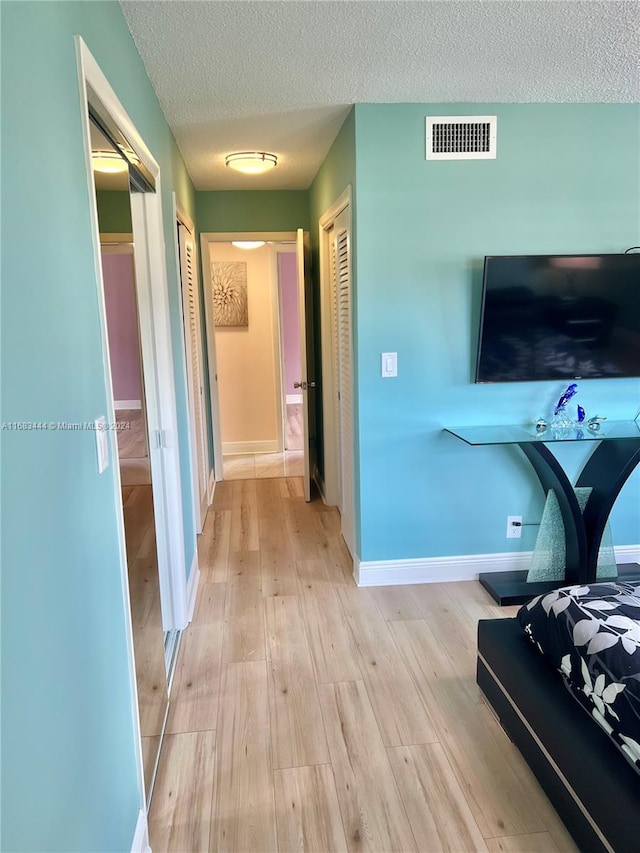 interior space with light hardwood / wood-style flooring and a textured ceiling