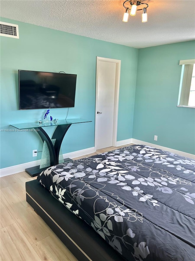 bedroom featuring wood-type flooring and a textured ceiling