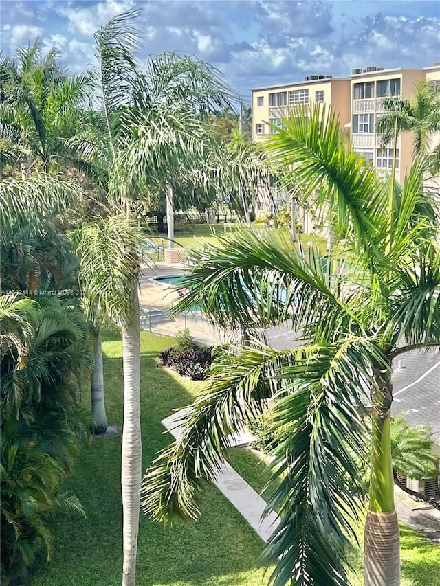 view of home's community with a pool and a yard