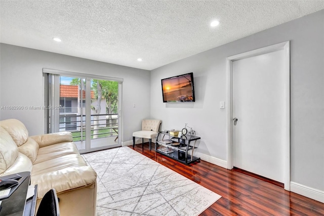 living room featuring a textured ceiling and dark hardwood / wood-style floors