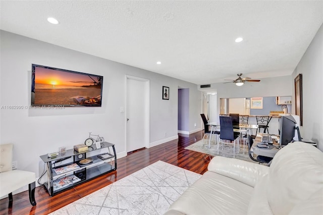 living room featuring hardwood / wood-style floors, a textured ceiling, and ceiling fan