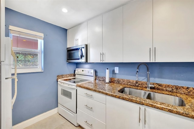 kitchen with dark stone countertops, white cabinets, sink, and electric range