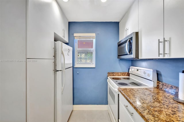 kitchen with white appliances, stone countertops, light tile patterned floors, and white cabinets