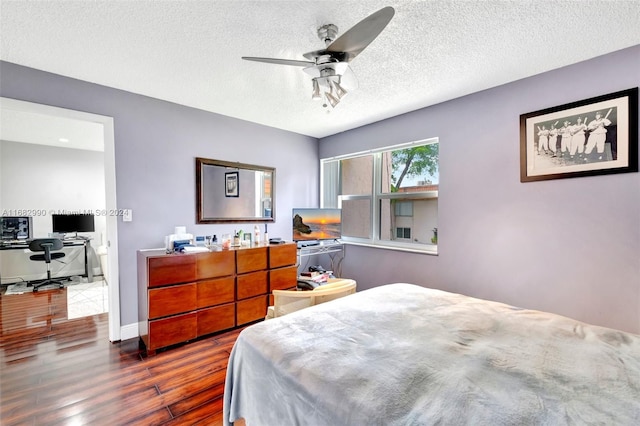 bedroom featuring a textured ceiling, dark hardwood / wood-style floors, and ceiling fan