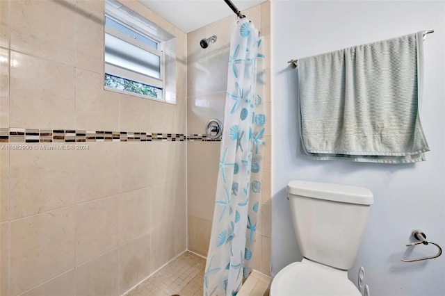 bathroom featuring tile patterned floors, toilet, and walk in shower