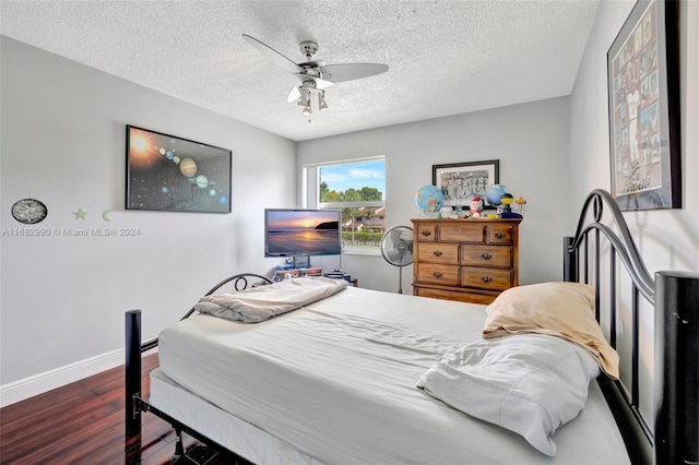 bedroom featuring ceiling fan, a textured ceiling, and dark hardwood / wood-style flooring