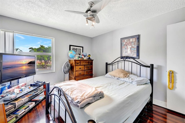 bedroom with dark hardwood / wood-style flooring, a textured ceiling, and ceiling fan