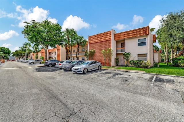 view of parking / parking lot featuring a lawn