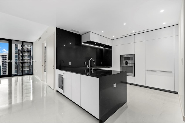 kitchen with white cabinets, dark countertops, modern cabinets, expansive windows, and french doors