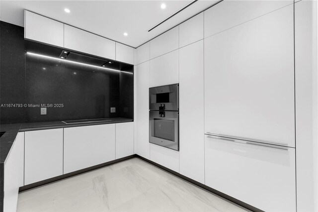 kitchen with white cabinetry and multiple ovens