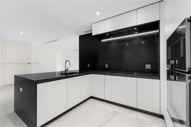 kitchen with a sink, white cabinetry, black stovetop, dark countertops, and modern cabinets