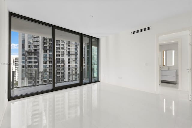 spare room with floor to ceiling windows and visible vents