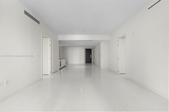 unfurnished room featuring light tile patterned flooring, visible vents, and baseboards