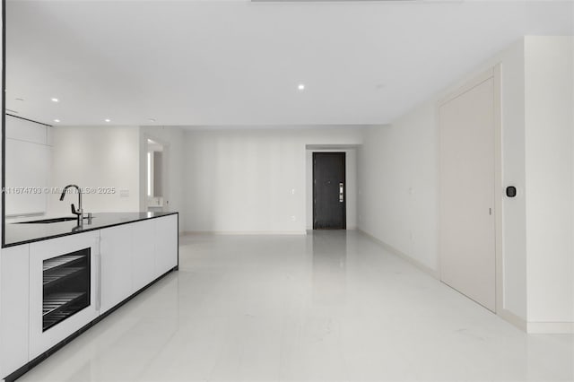 kitchen featuring modern cabinets, white cabinets, a sink, and recessed lighting