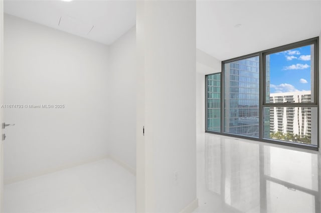 bathroom featuring floor to ceiling windows and baseboards