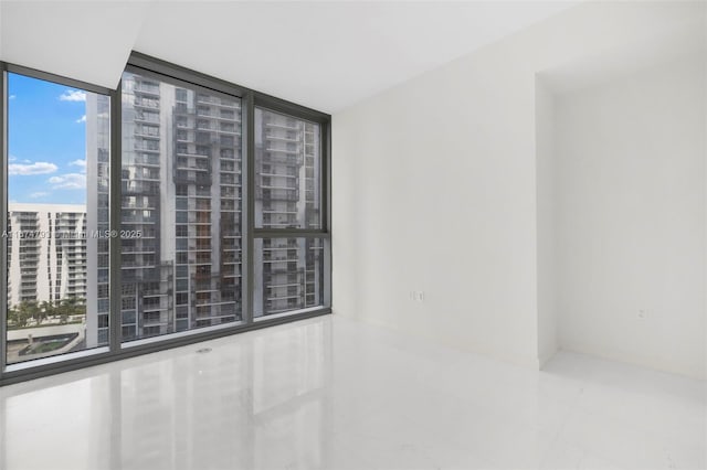 spare room featuring a wall of windows and a city view