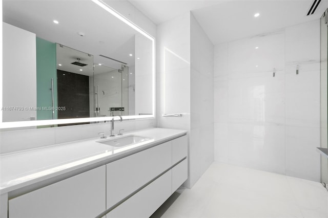 full bath with a marble finish shower, vanity, and recessed lighting