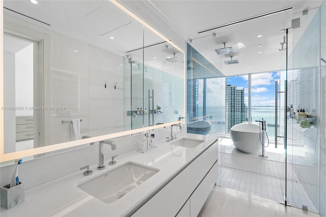 bathroom featuring vanity, tile patterned floors, independent shower and bath, and a wall of windows