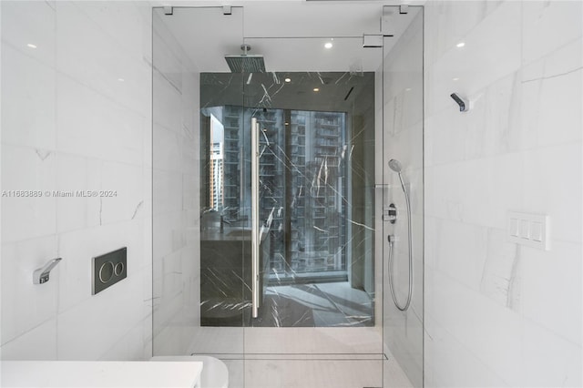 bathroom with a tile shower and toilet