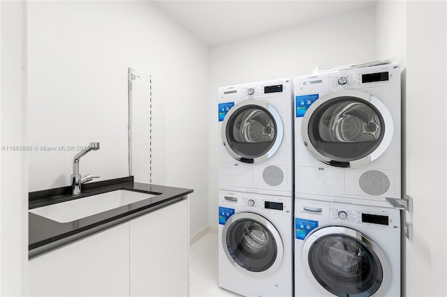 laundry area featuring sink, stacked washer and dryer, and washing machine and clothes dryer