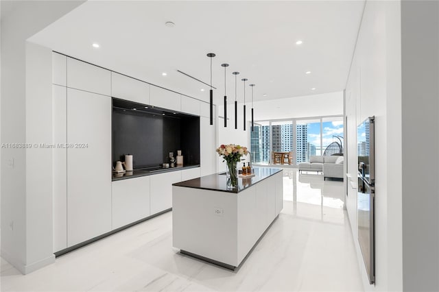 kitchen with a kitchen island, white cabinets, and hanging light fixtures