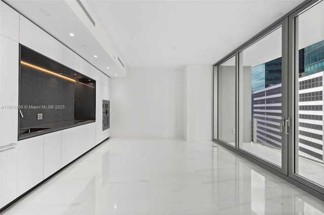 interior space with recessed lighting, marble finish floor, white cabinets, and modern cabinets