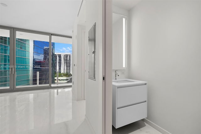 interior space featuring marble finish floor, vanity, and baseboards